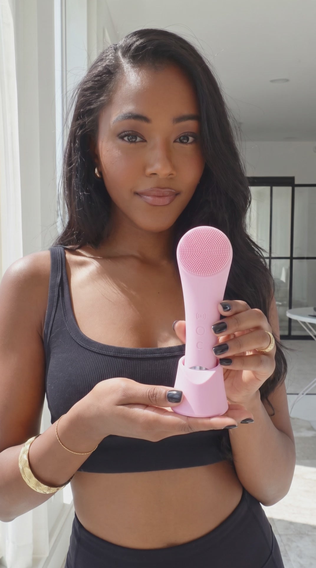 She Glow Heated Sonic Facial Cleansing Brush — blush pink silicone brush in charging stand